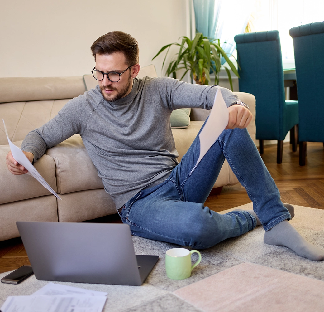 Man sitting on ground and looking at paper work