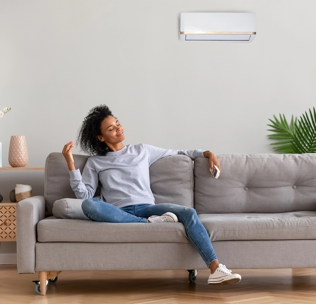 Woman relaxing on the couch with A/C blowing on her