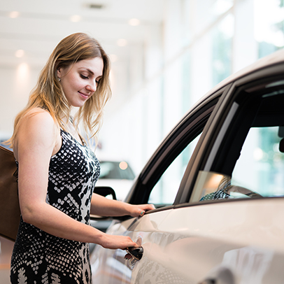 Happy blonde girl looking for her new fancy car