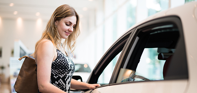 Happy blonde girl looking for her new fancy car