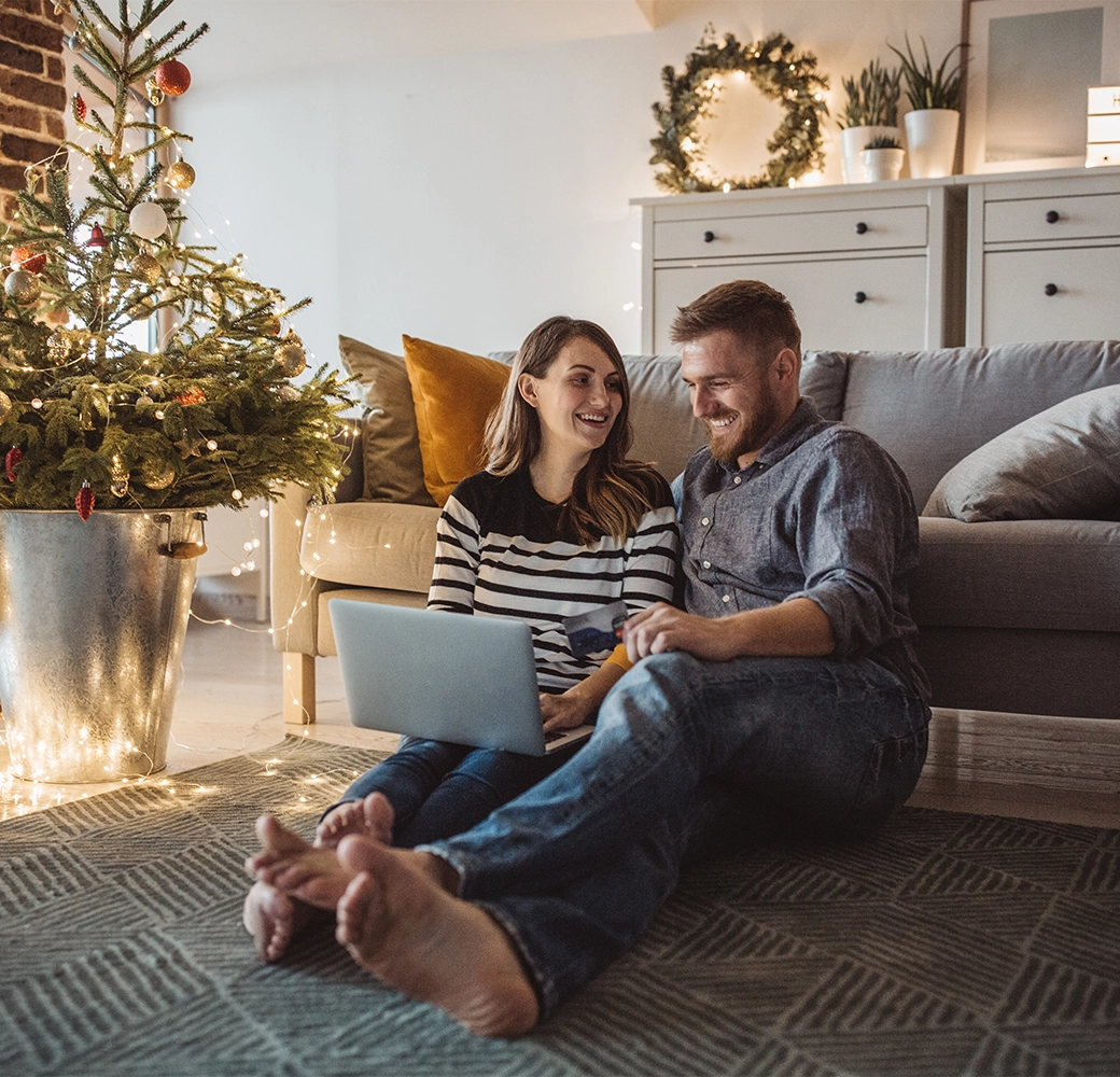 Couple smiling by Christmas tree