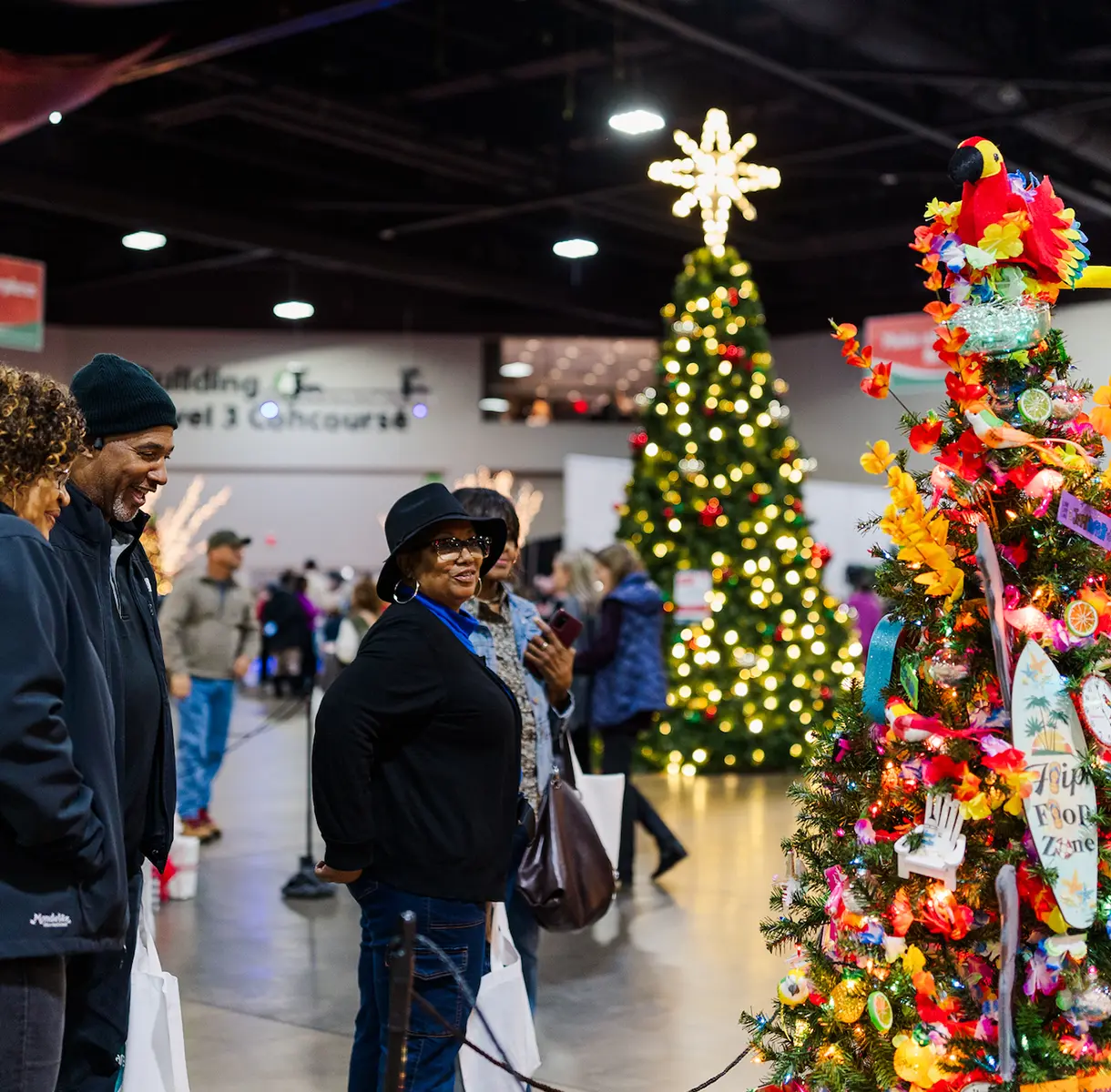Group of people admiring decorated trees at Festival of Trees