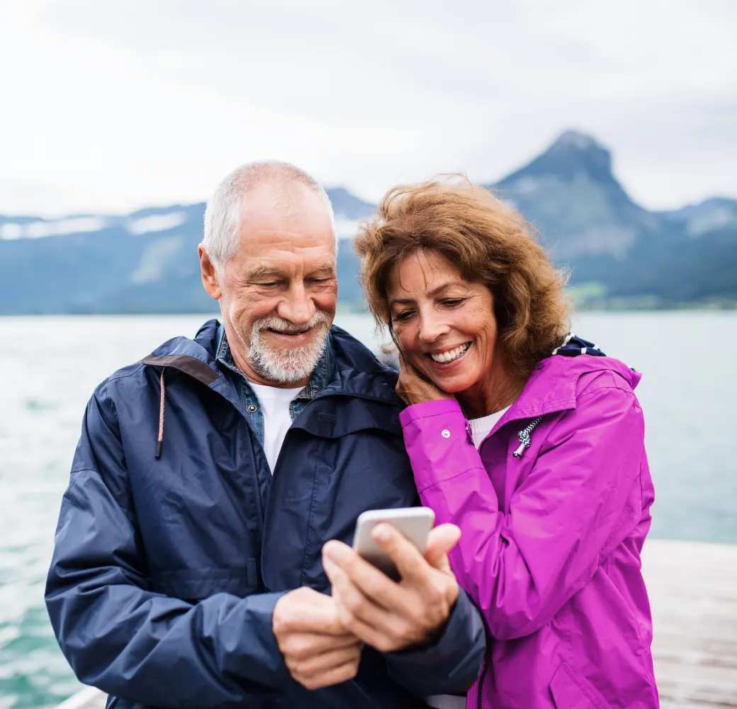 Mature couple outside and looking at cell phone