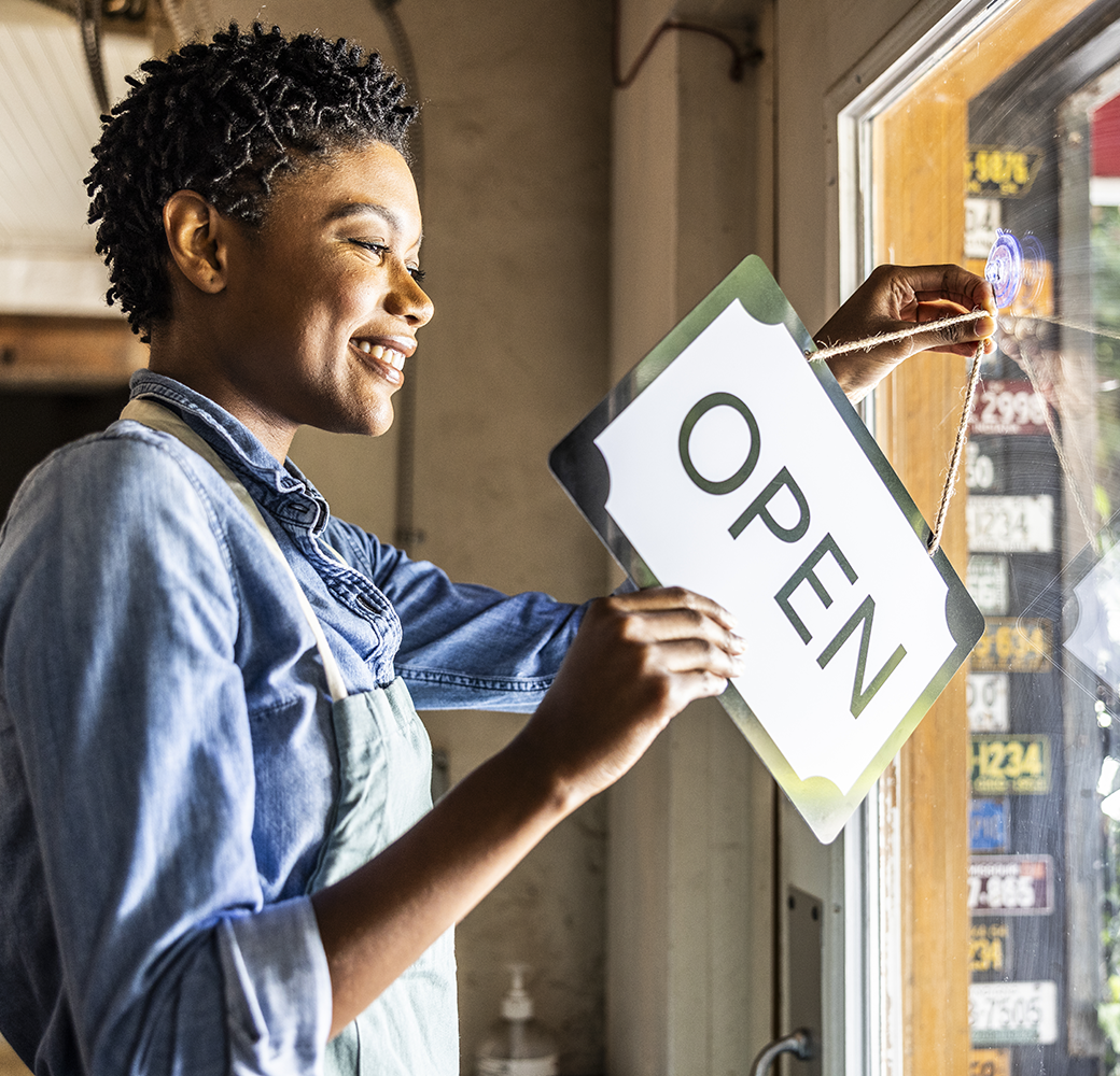 Black woman flipping sign in business window to 