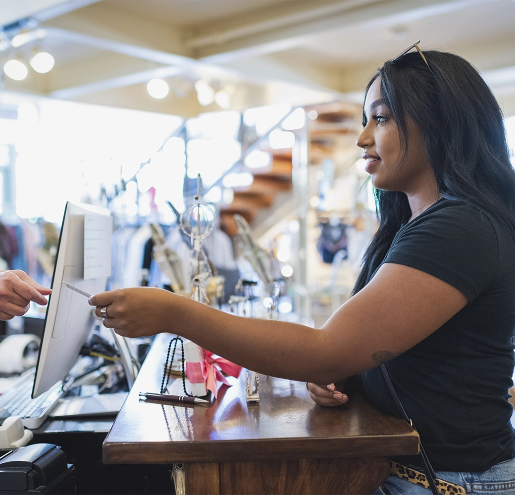 Woman paying at cash register with credit card