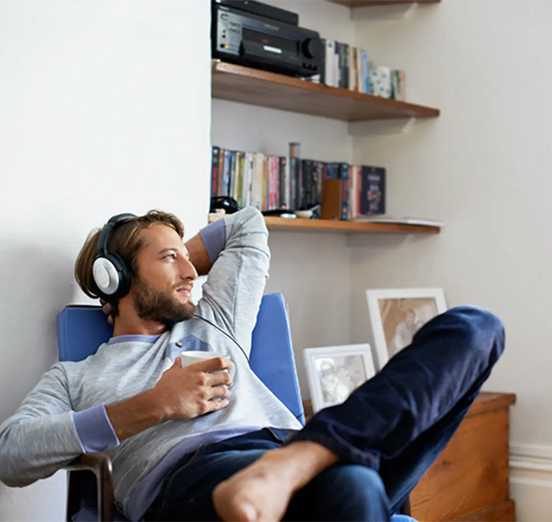 Man sitting at home and listening to music through his head phones