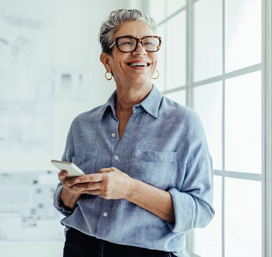 Older woman smiling holding a phone