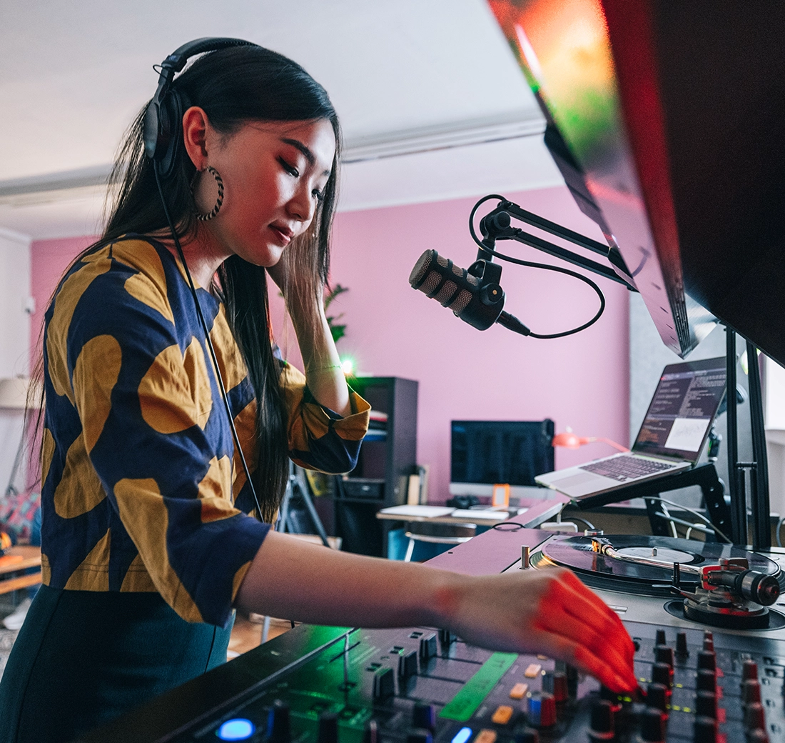 Woman with headphones using a synthesizer