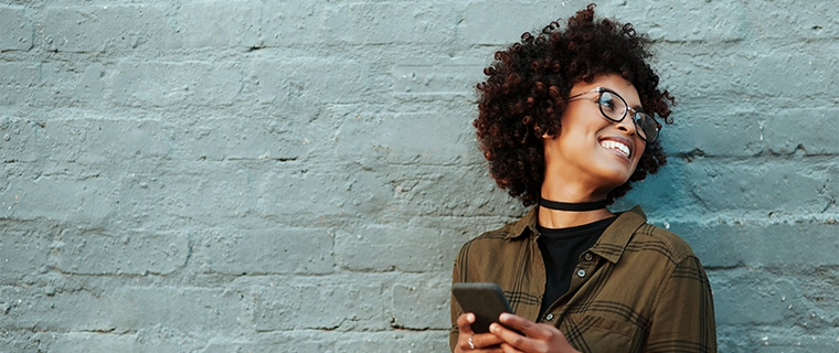 Woman holding phone and smiling