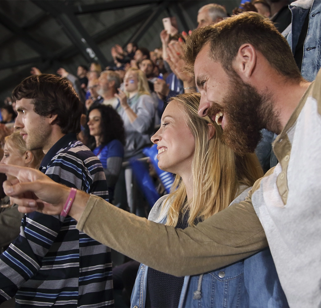 Man and woman cheering team on at sporting event