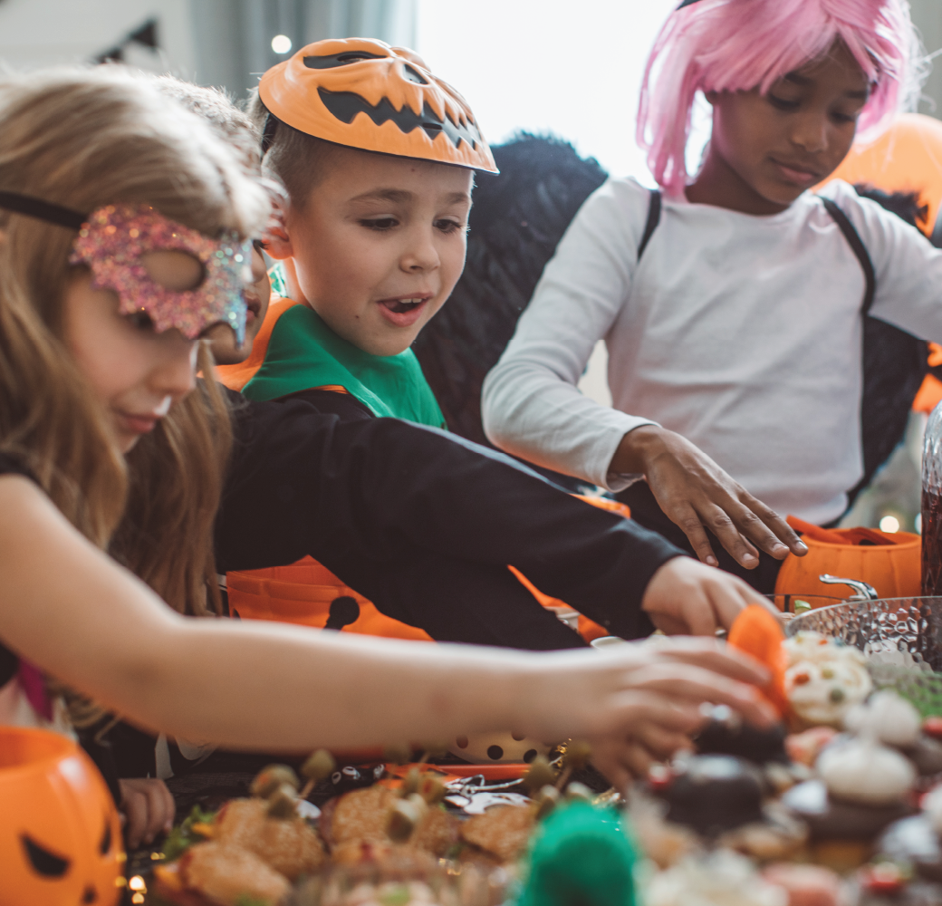Multi ethnic group of children wearing Halloween costumes having a Halloween party at home.