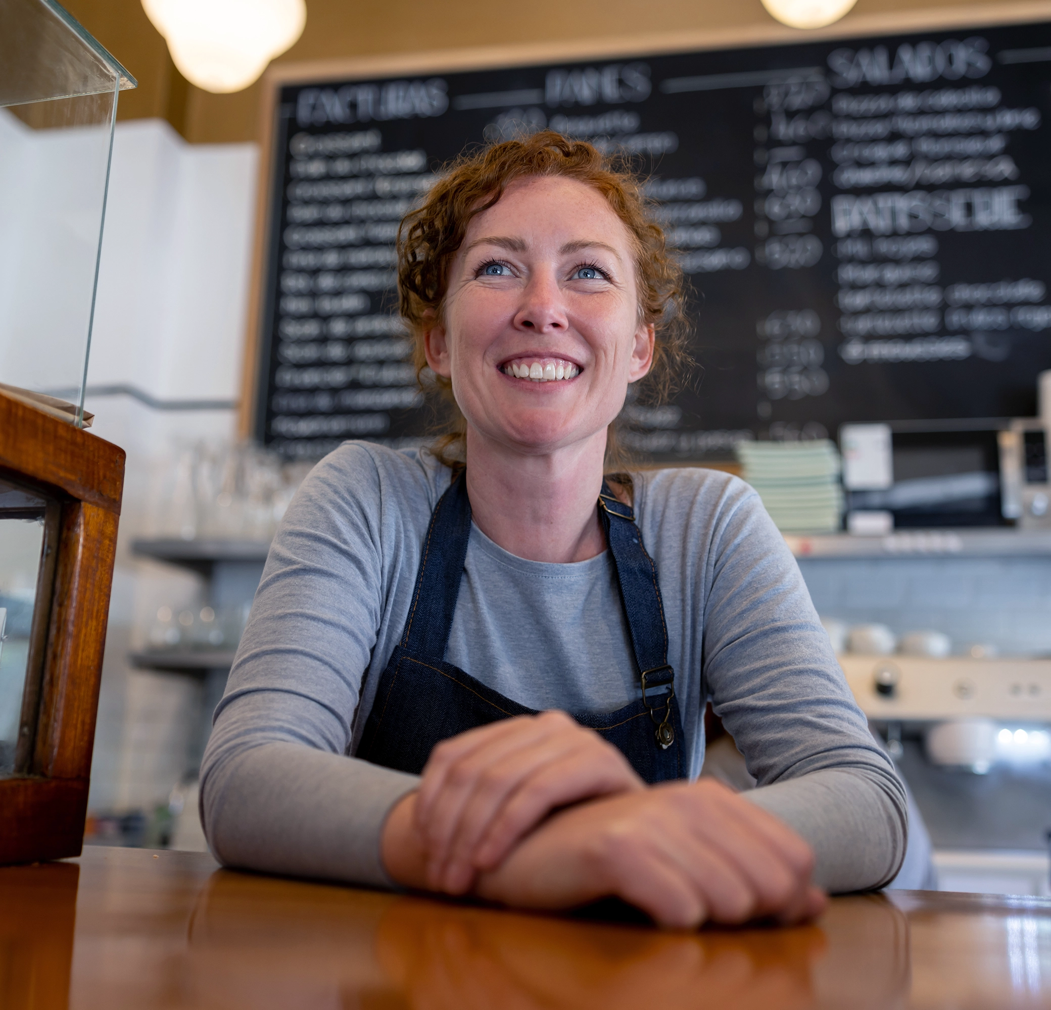 Woman smiling behind a counter in a cafe