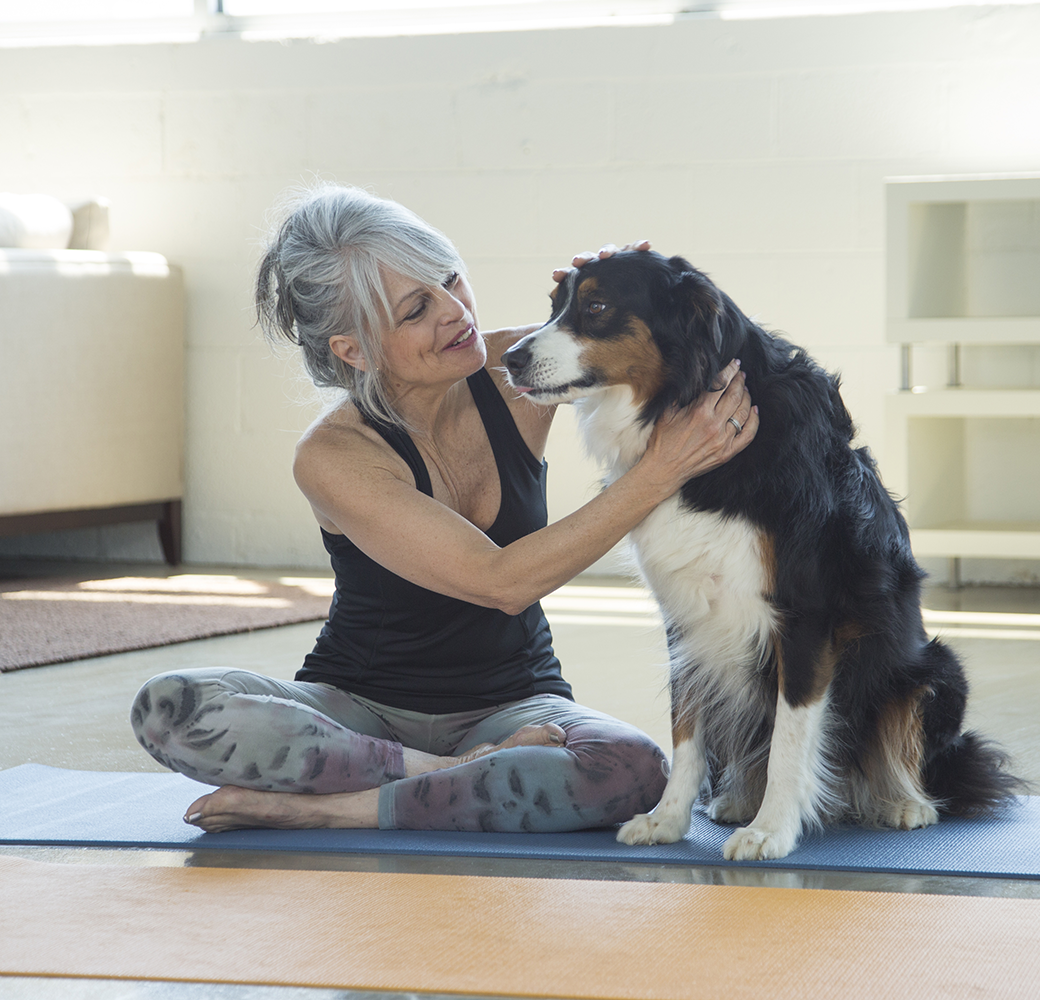 Woman on yoga mat with dog