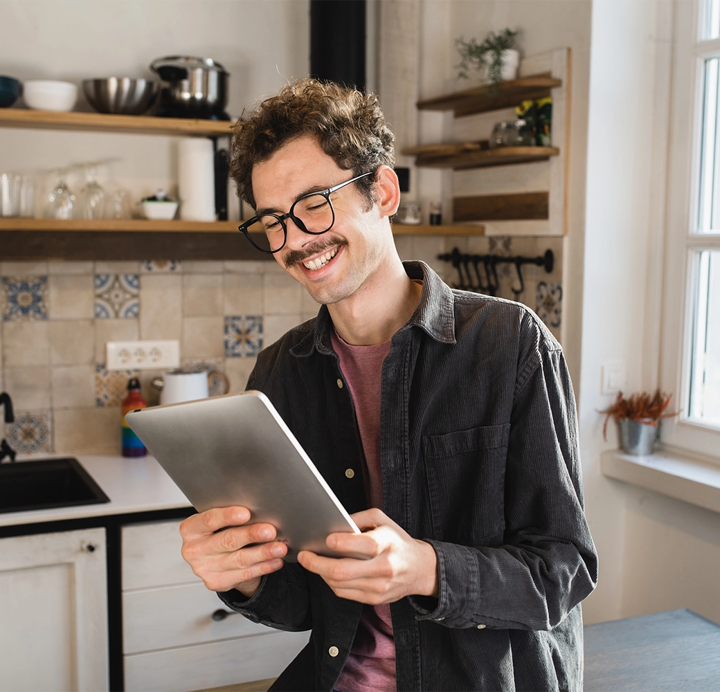Man smiling and looking at tablet device