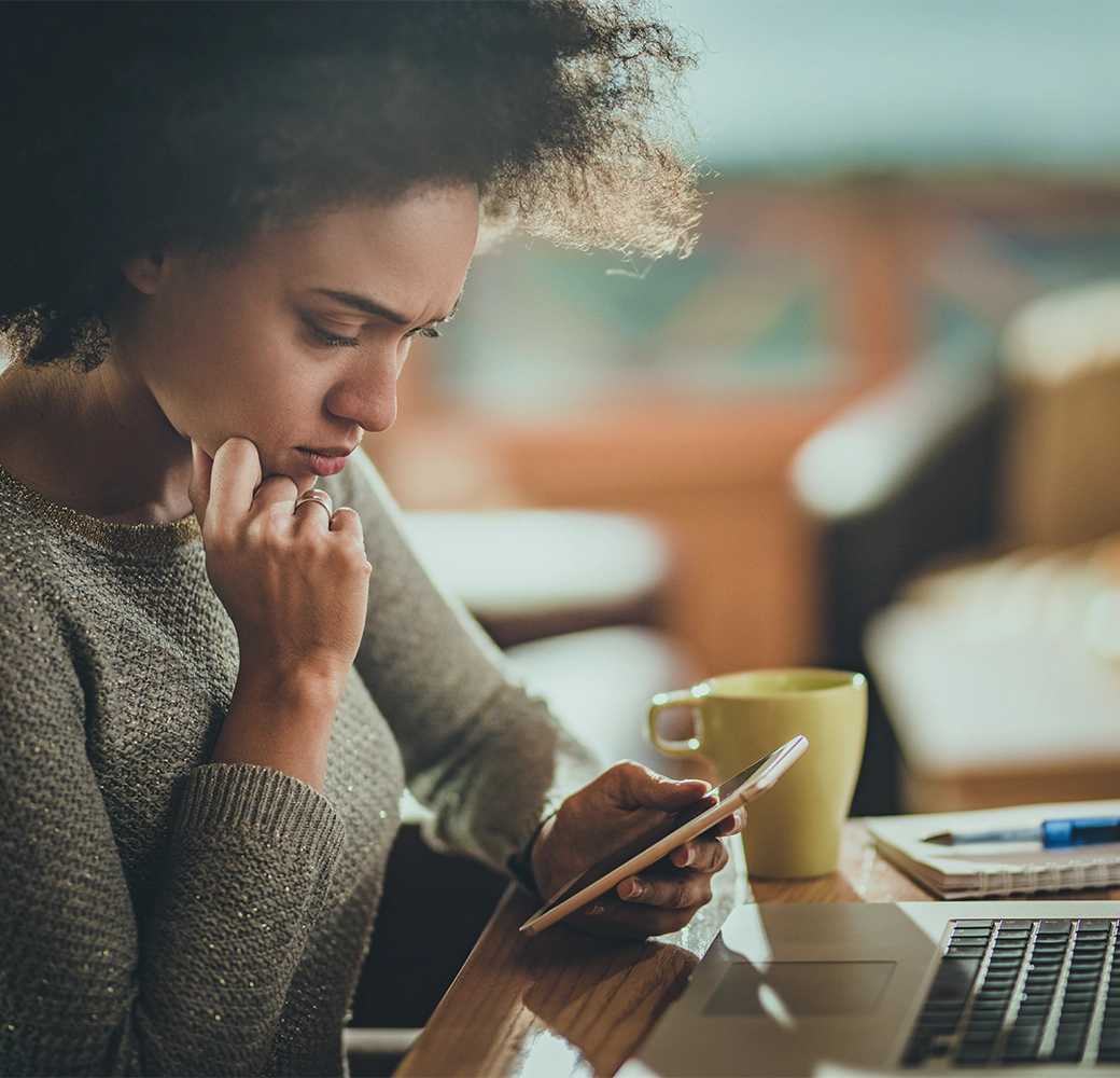 Upset woman looking at her cellphone