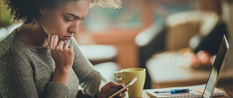 Upset woman looking at her cellphone