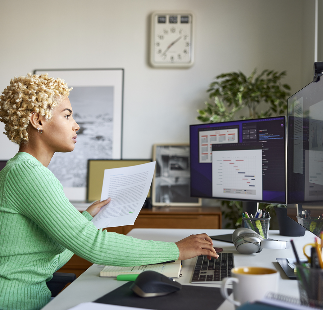 Black woman with blonde hair in green top on computer