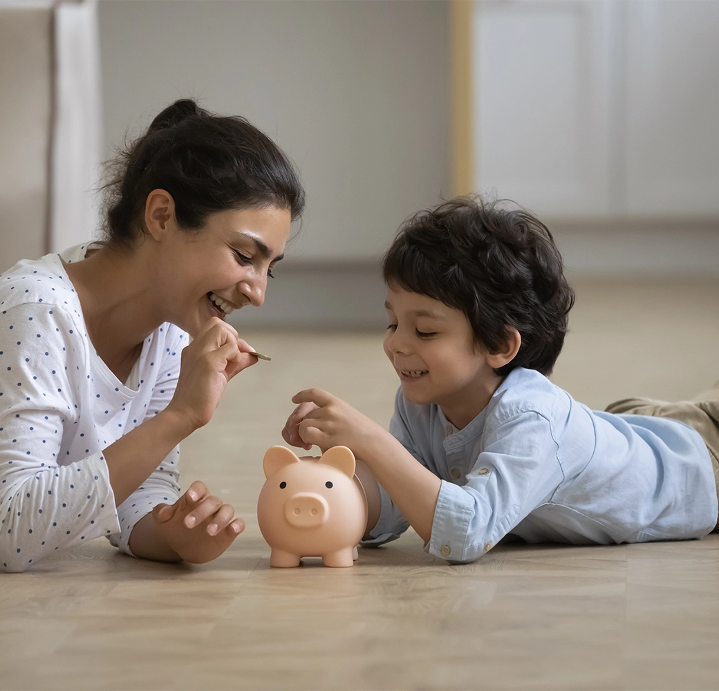 Mother and son putting money into a piggy bank