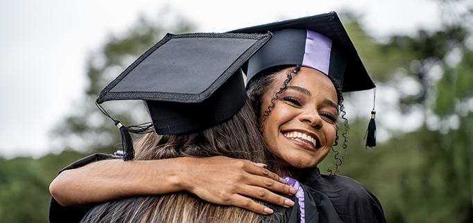 Hug of young people celebrating graduation day