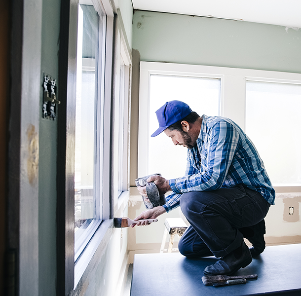 Man painting interior window