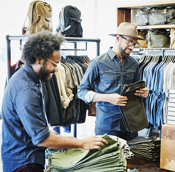 Man with glasses and man with hat shopping for clothes