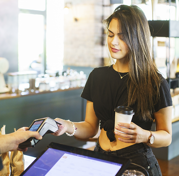 Woman at coffee shop using tap to pay