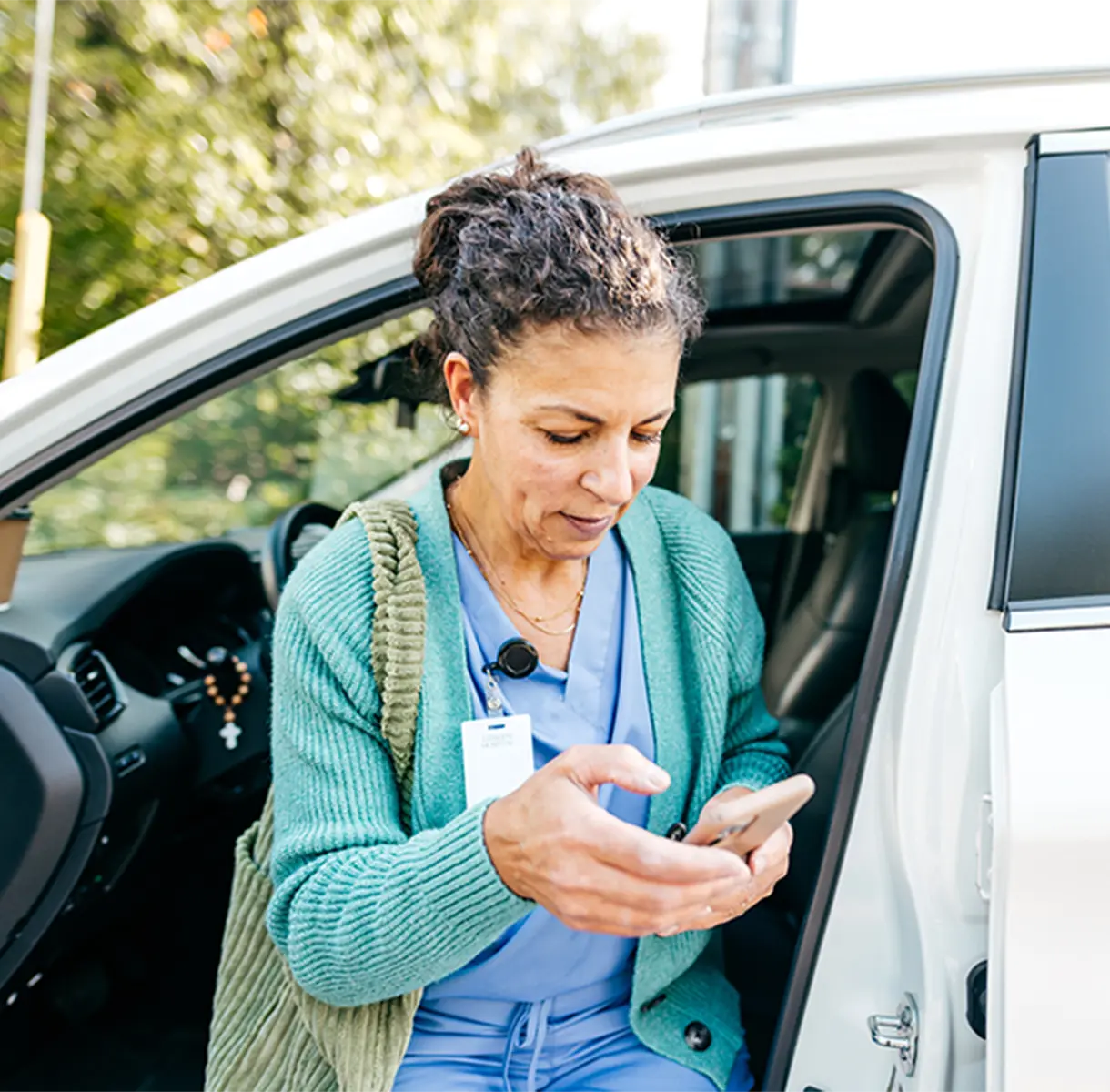 Woman coming out of car and looking at her phone