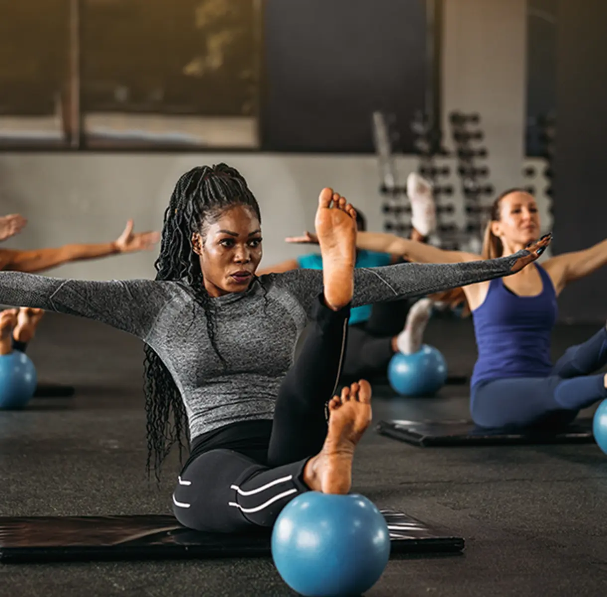 Woman working out in group class with yoga ball
