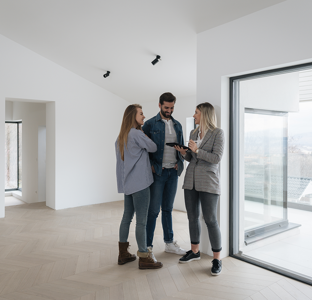 Couple with real estate agent inside empty house