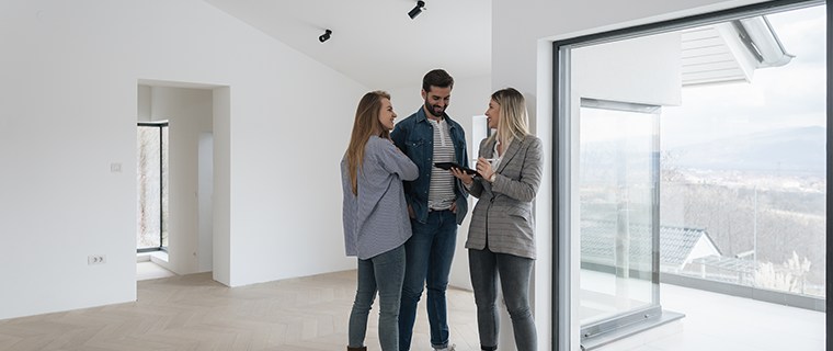 Couple with real estate agent inside empty house