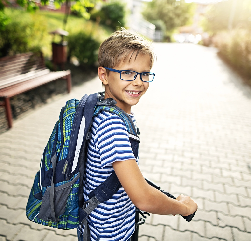 Young boy wearing a backpack and walking to school
