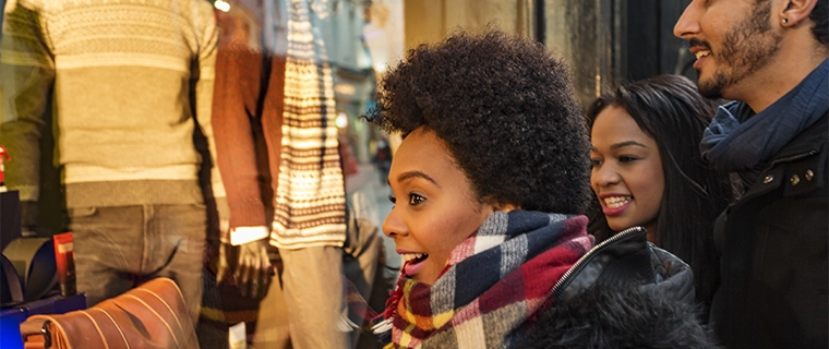 Women happily holiday shopping and looking at a purse