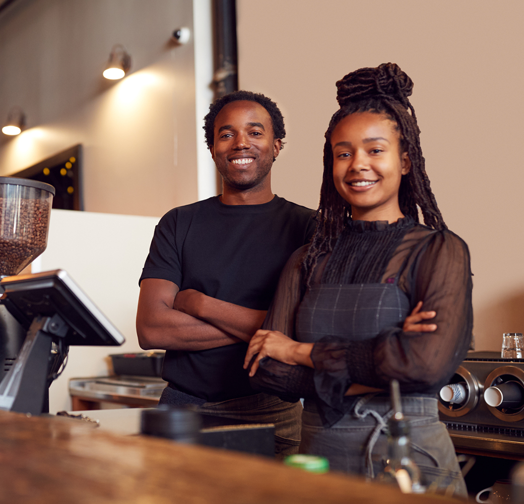 Black man and Black woman standing at coffee shop counter