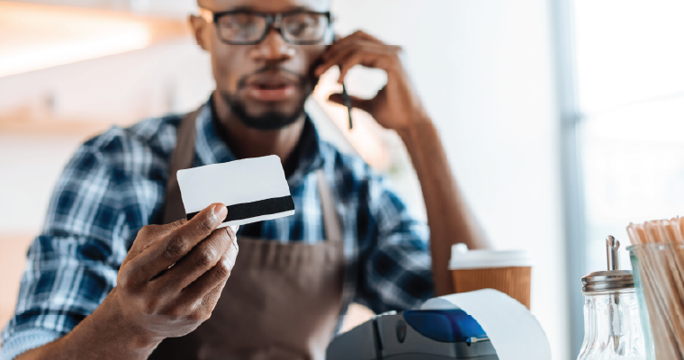 Understanding user access.Man looking at credit card while on the phone.