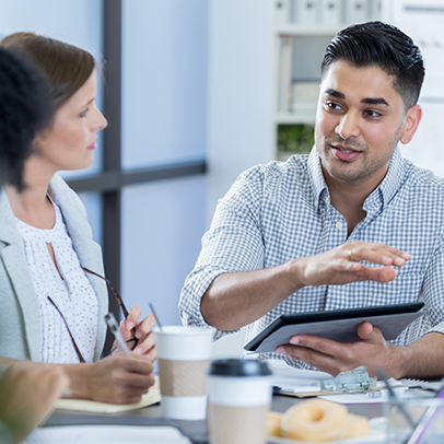 Attentive businesspeople listen to colleague during a morning staff meeting.