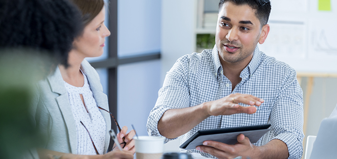 Attentive businesspeople listen to colleague during a morning staff meeting.