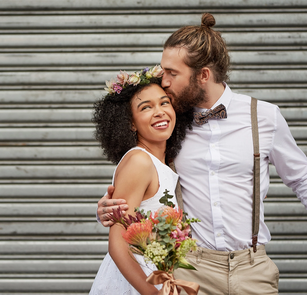 Groom kissing bride on the forehead