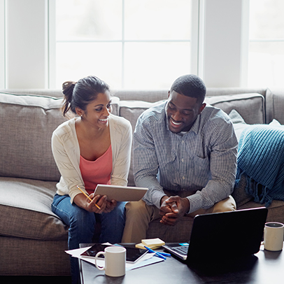 Shot of a young couple going through paperwork together on the sofa at home