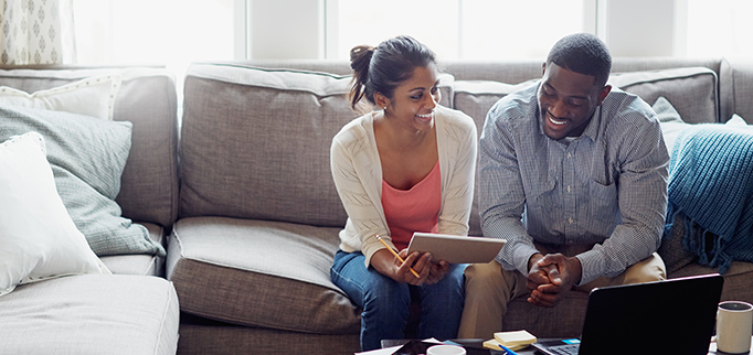 Shot of a young couple going through paperwork together on the sofa at home