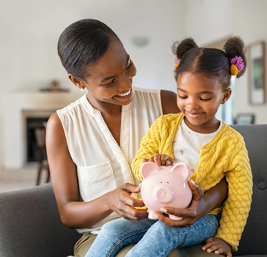 Mom and daughter holding a piggy bank