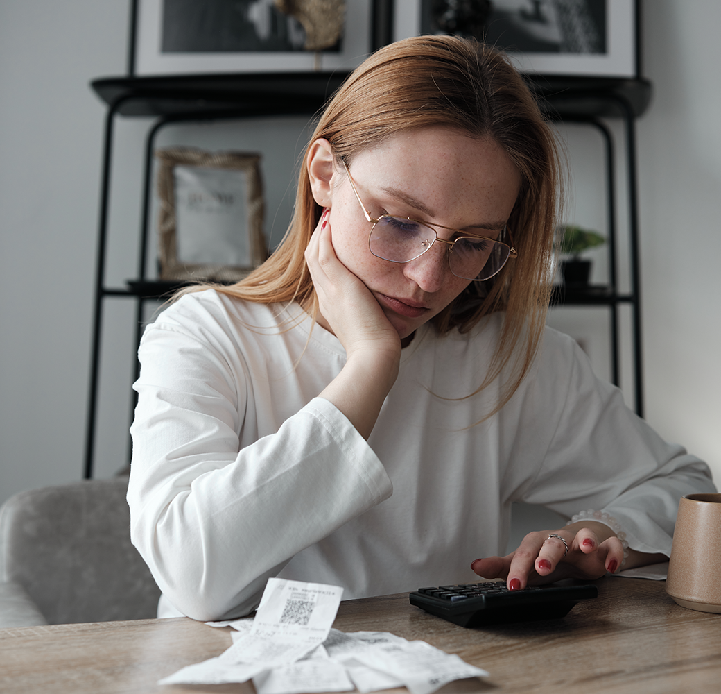 Woman sitting at desk looking at receipts